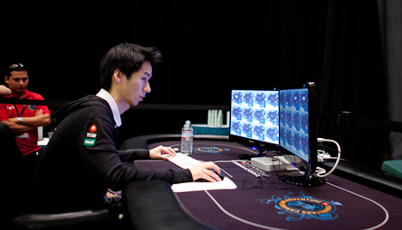 Randy Lew usando una computadora encima de una mesa de poker